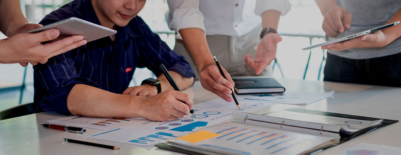 Pessoas escrevendo em documentos no escritório