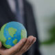 homem segurando um globo terrestre pequeno