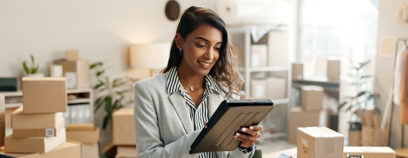 Mulher analisando o tablet no seu escritório de e-commerce